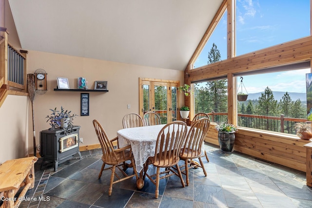 1529 S Saddleback Dr, Coeur Dalene, ID 83814 - dining room with stone tile flooring, a wood stove, french doors, and high vaulted ceiling