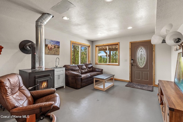 1529 S Saddleback Dr, Coeur Dalene, ID 83814 - living room with concrete floors, a textured ceiling, recessed lighting, and a wood stove