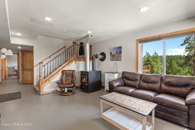 1529 S Saddleback Dr, Coeur Dalene, ID 83814 - living area featuring finished concrete flooring, recessed lighting, a textured ceiling, a wood stove, and stairs