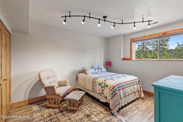 1529 S Saddleback Dr, Coeur Dalene, ID 83814 - bedroom with light wood-style flooring and rail lighting