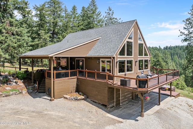 1529 S Saddleback Dr, Coeur Dalene, ID 83814 - rear view of house featuring roof with shingles, a wooden deck, and a wooded view