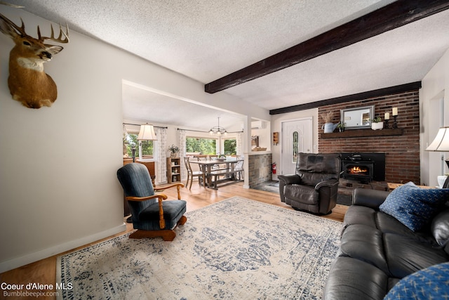19441 N Rustic Ridge Trl, Rathdrum, ID 83858 - living area with a textured ceiling, wood finished floors, beam ceiling, and a fireplace