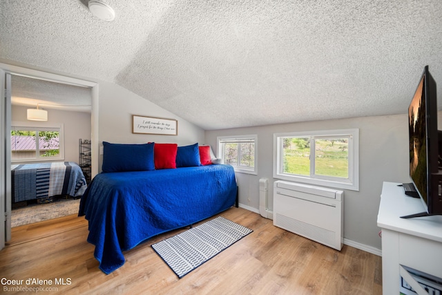 19441 N Rustic Ridge Trl, Rathdrum, ID 83858 - bedroom with a textured ceiling, wood finished floors, lofted ceiling, and multiple windows