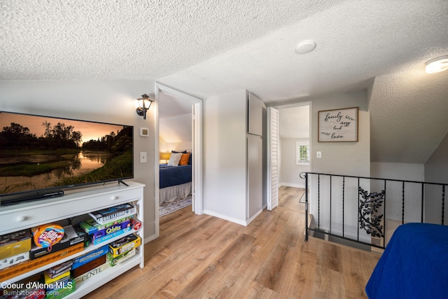 19441 N Rustic Ridge Trl, Rathdrum, ID 83858 - hallway with an upstairs landing, a textured ceiling, wood finished floors, and vaulted ceiling