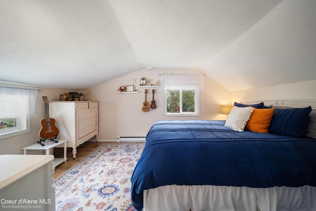 19441 N Rustic Ridge Trl, Rathdrum, ID 83858 - bedroom featuring a baseboard radiator, wood finished floors, lofted ceiling, and a textured ceiling