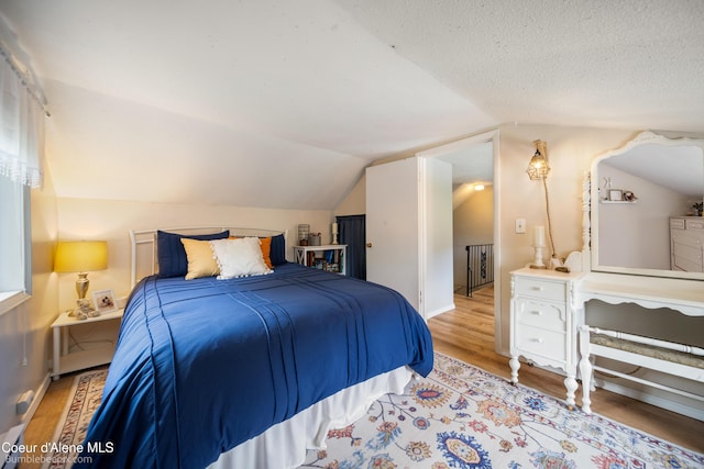 19441 N Rustic Ridge Trl, Rathdrum, ID 83858 - bedroom with lofted ceiling, wood finished floors, and a textured ceiling