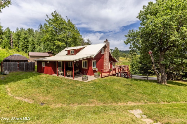 19441 N Rustic Ridge Trl, Rathdrum, ID 83858 - back of house with a chimney, a patio, and a yard