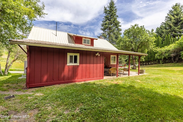 19441 N Rustic Ridge Trl, Rathdrum, ID 83858 - view of property exterior featuring a patio, a lawn, a metal roof, and board and batten siding