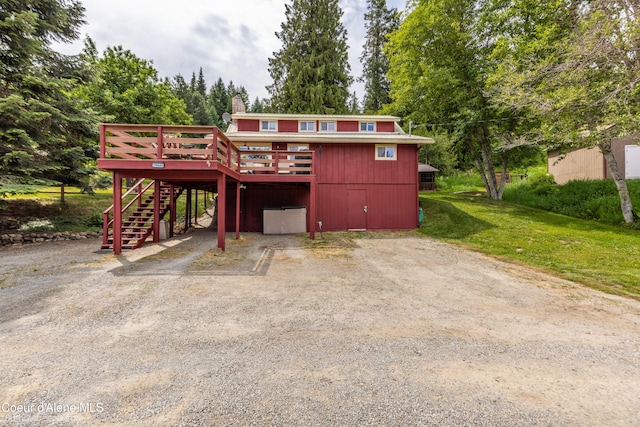 19441 N Rustic Ridge Trl, Rathdrum, ID 83858 - view of front of property featuring stairway, dirt driveway, a deck, a front yard, and a carport