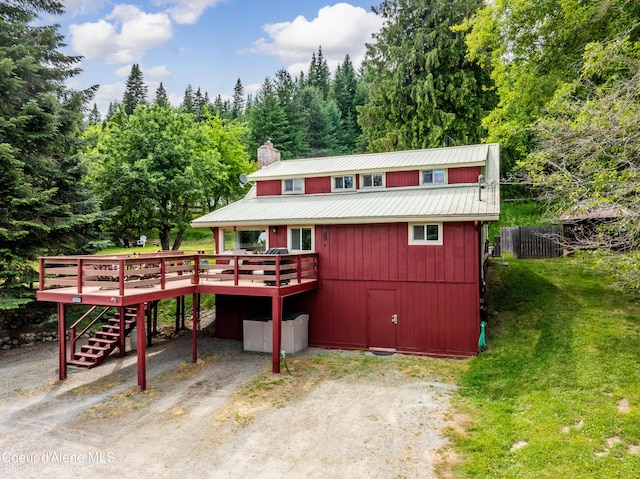19441 N Rustic Ridge Trl, Rathdrum, ID 83858 - view of front of home featuring a deck, stairs, a metal roof, a chimney, and driveway