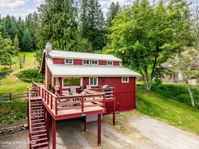 19441 N Rustic Ridge Trl, Rathdrum, ID 83858 - view of front of home with a chimney, a metal roof, a wooden deck, and stairs