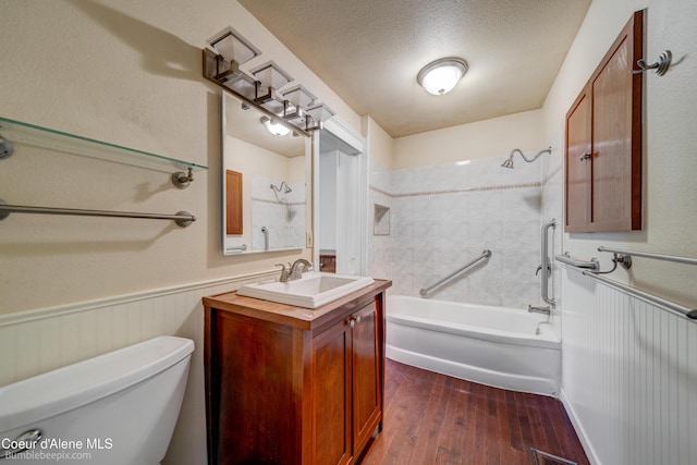 421 W Walnut Ave, Coeur Dalene, ID 83814 - full bath with vanity, wood-type flooring, washtub / shower combination, a wainscoted wall, and a textured ceiling