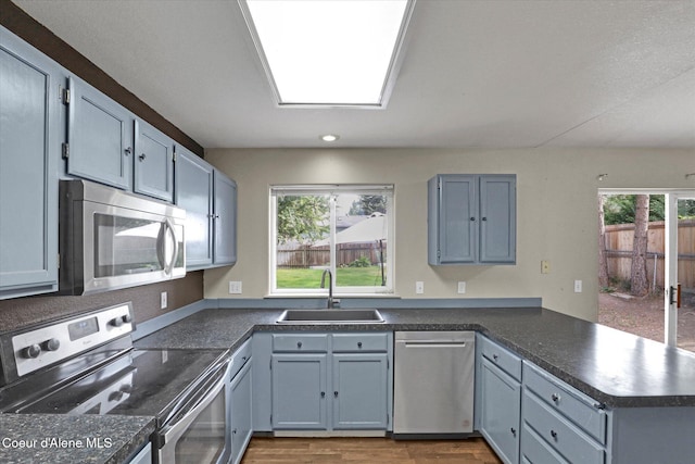 7575 W Crenshaw St, Rathdrum, ID 83858 - kitchen with stainless steel appliances, a peninsula, dark countertops, recessed lighting, and wood finished floors