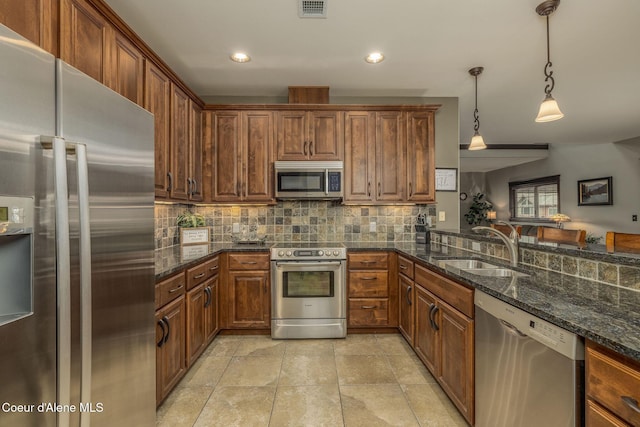 2050 N Main St, Coeur Dalene, ID 83814 - kitchen featuring appliances with stainless steel finishes, backsplash, pendant lighting, recessed lighting, and dark stone counters