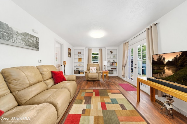 1025 N 1st St, Coeur Dalene, ID 83814 - living area with wood finished floors, built in shelves, french doors, and a textured ceiling