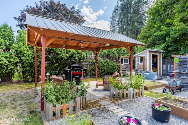 1025 N 1st St, Coeur Dalene, ID 83814 - view of patio featuring a vegetable garden, a gazebo, and a storage unit