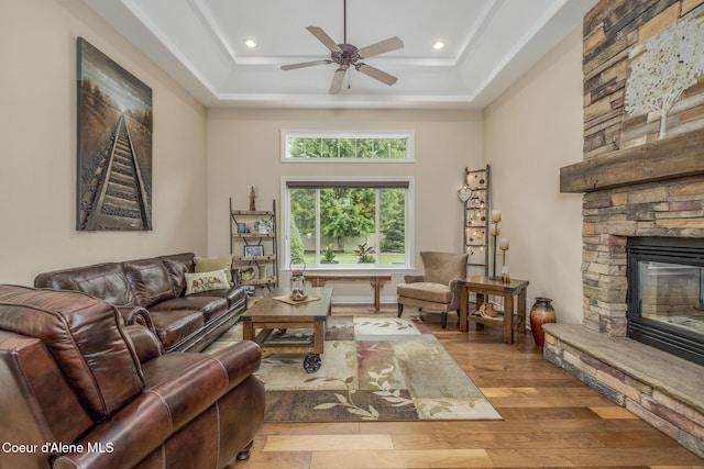 12608 N Shamrock St, Hayden, ID 83835 - living room with hardwood / wood-style flooring, a stone fireplace, ceiling fan, a raised ceiling, and recessed lighting