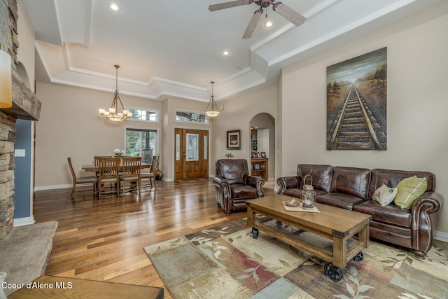 12608 N Shamrock St, Hayden, ID 83835 - living area featuring a tray ceiling, arched walkways, light wood finished floors, a ceiling fan, and a chandelier
