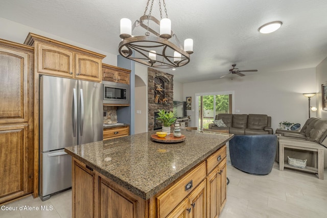 12608 N Shamrock St, Hayden, ID 83835 - kitchen featuring stainless steel appliances, ceiling fan, a center island, a chandelier, and brown cabinets