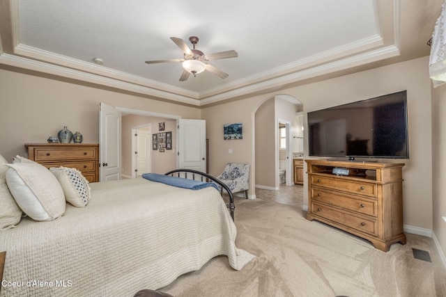 12608 N Shamrock St, Hayden, ID 83835 - bedroom featuring arched walkways, ornamental molding, light carpet, a tray ceiling, and ensuite bathroom