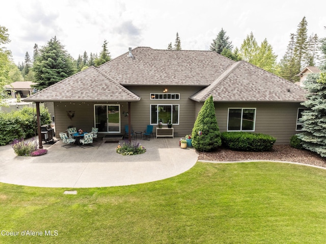12608 N Shamrock St, Hayden, ID 83835 - back of property with a shingled roof, a lawn, a patio area, and an outdoor hangout area