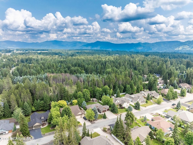 12608 N Shamrock St, Hayden, ID 83835 - aerial perspective of suburban area featuring a heavily wooded area and a mountainous background