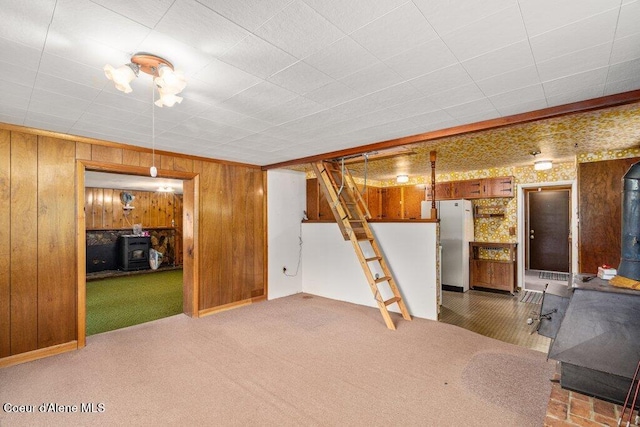 1875 S Gateway Ranch Rd, Coeur Dalene, ID 83814 - finished basement with a wood stove, carpet, wood walls, and freestanding refrigerator