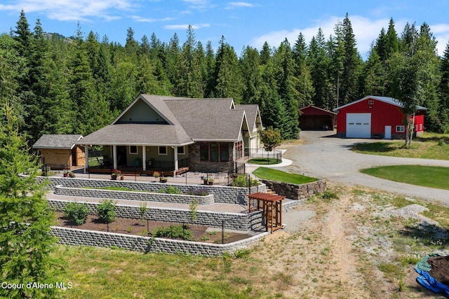 4127 Sagle Rd, Sagle, ID 83860 - back of house featuring dirt driveway, covered porch, an outbuilding, a garage, and a wooded view