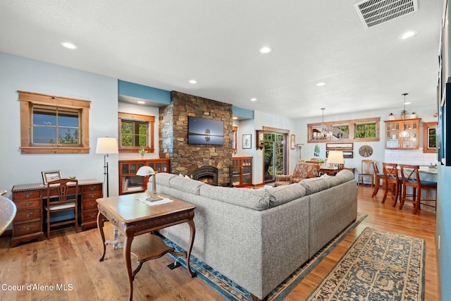 4127 Sagle Rd, Sagle, ID 83860 - living area featuring a stone fireplace, wood finished floors, recessed lighting, and a chandelier