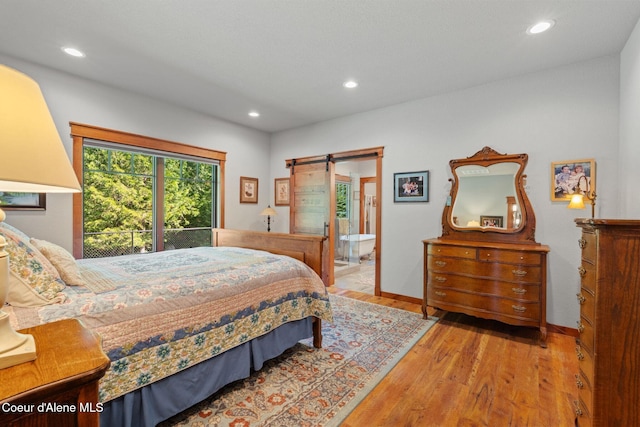 4127 Sagle Rd, Sagle, ID 83860 - bedroom featuring a barn door, wood finished floors, recessed lighting, and connected bathroom