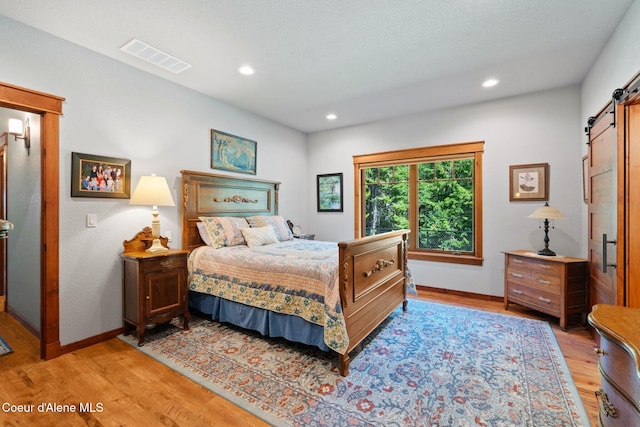 4127 Sagle Rd, Sagle, ID 83860 - bedroom featuring a barn door, light wood-style floors, and recessed lighting