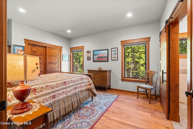 4127 Sagle Rd, Sagle, ID 83860 - bedroom featuring a barn door, light wood-type flooring, and recessed lighting