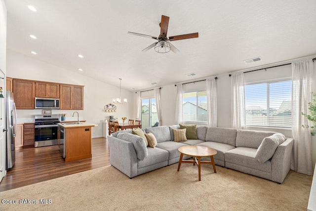 10514 N Liverpool Loop, Hayden, ID 83835 - carpeted living area with recessed lighting, vaulted ceiling, a ceiling fan, a chandelier, and wood finished floors