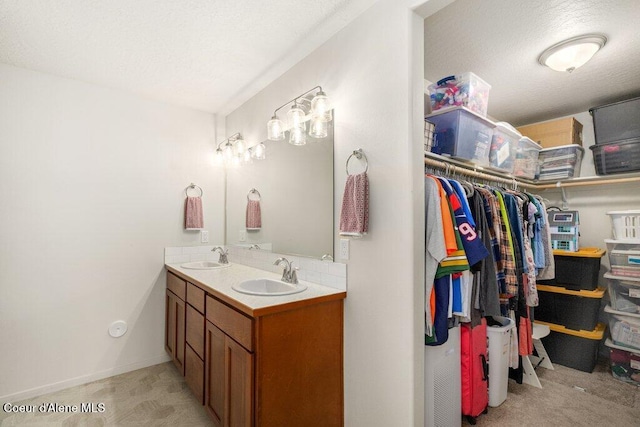 10514 N Liverpool Loop, Hayden, ID 83835 - bathroom featuring double vanity, a walk in closet, and a textured ceiling
