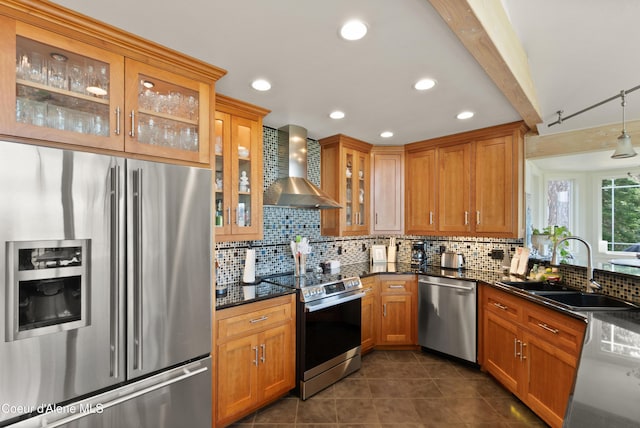 5143 W Crazy Creek Rd, Coeur Dalene, ID 83814 - kitchen with stainless steel appliances, wall chimney range hood, backsplash, dark tile patterned floors, and brown cabinetry