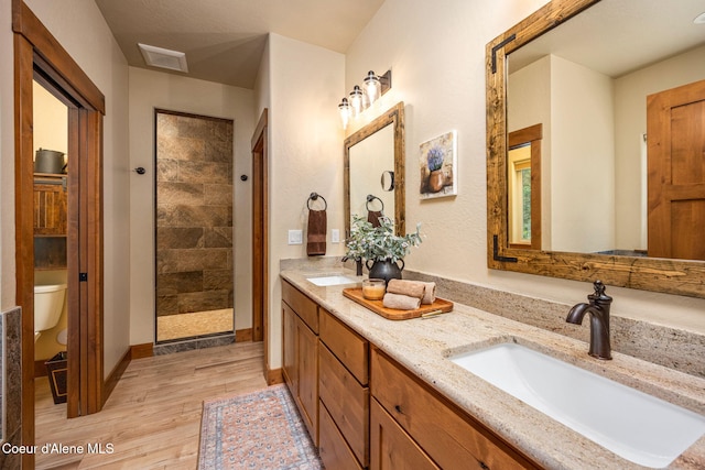 21315 N Eclipse Rd, Rathdrum, ID 83858 - bathroom with wood finished floors, double vanity, and tiled shower
