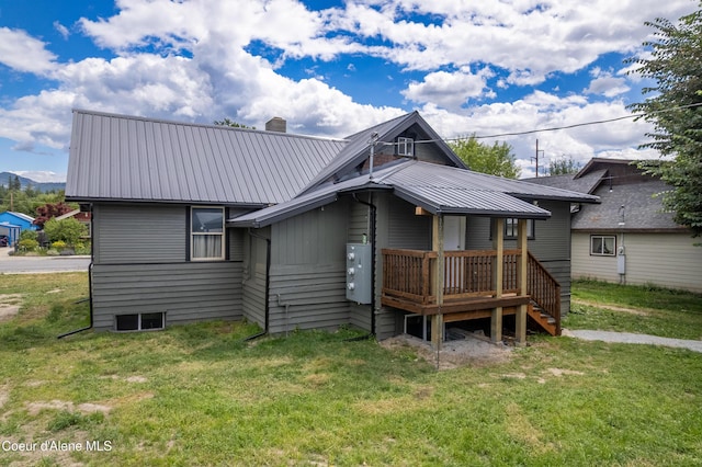 110 Cedar St, Priest River, ID 83856 - rear view of property with a metal roof, a chimney, a lawn, and a wooden deck