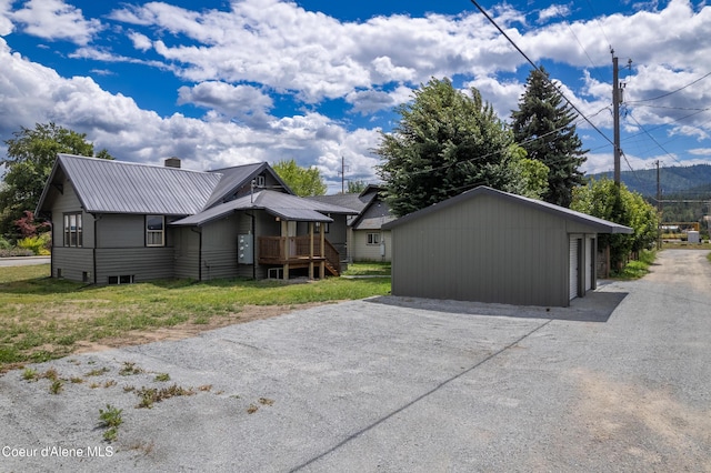 110 Cedar St, Priest River, ID 83856 - view of side of property with an outdoor structure, a metal roof, a chimney, and a garage