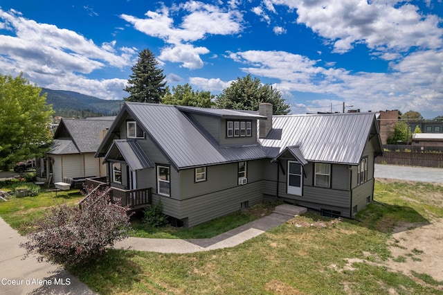 110 Cedar St, Priest River, ID 83856 - view of front of home featuring a metal roof, a front lawn, a chimney, and a mountain view