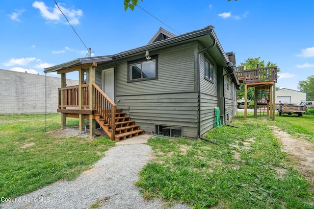 110 Cedar St, Priest River, ID 83856 - rear view of house with stairs, a wooden deck, and a lawn