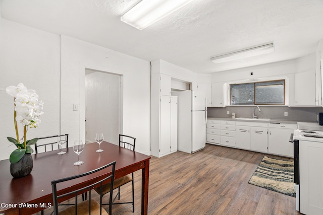 110 Cedar St, Priest River, ID 83856 - kitchen with white appliances, wood finished floors, white cabinets, light countertops, and a textured ceiling