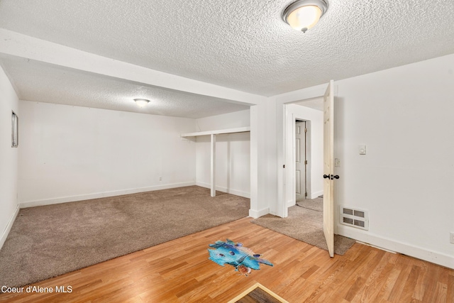110 Cedar St, Priest River, ID 83856 - below grade area featuring wood finished floors, a textured ceiling, and carpet floors