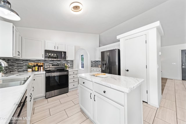 870 E Cloverleaf Dr, Hayden, ID 83835 - kitchen featuring appliances with stainless steel finishes, decorative backsplash, white cabinets, a center island, and light stone countertops