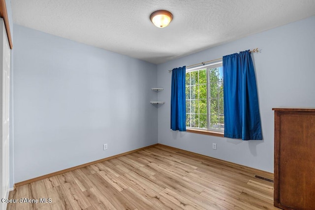5735 E Steamboat Bnd, Post Falls, ID 83854 - unfurnished room with wood finished floors and a textured ceiling