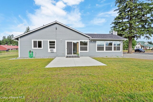 185 Leo Ln, Moyie Springs, ID 83845 - rear view of house with a patio area, a chimney, and a lawn