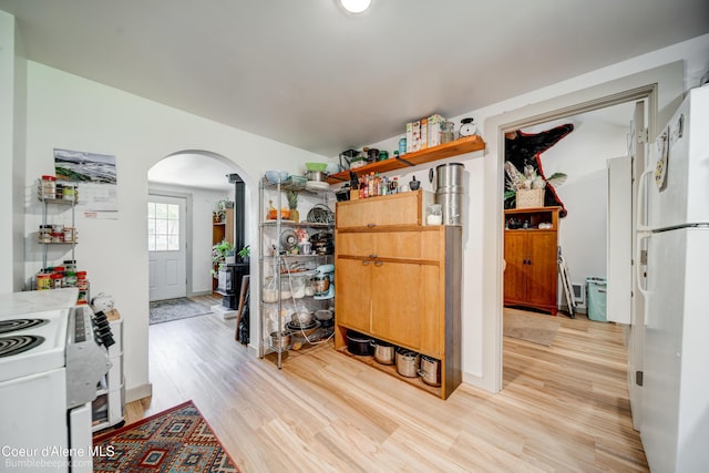 219 E 4th St, Oldtown, ID 83822 - kitchen with white appliances, arched walkways, light wood-style flooring, and open shelves