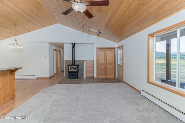 156 Promise Ln, Moyie Springs, ID 83845 - unfurnished living room featuring a baseboard radiator, a baseboard heating unit, vaulted ceiling, wooden ceiling, and a wood stove