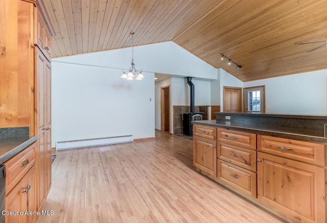 156 Promise Ln, Moyie Springs, ID 83845 - kitchen with baseboard heating, vaulted ceiling, a wood stove, dark countertops, and wood ceiling