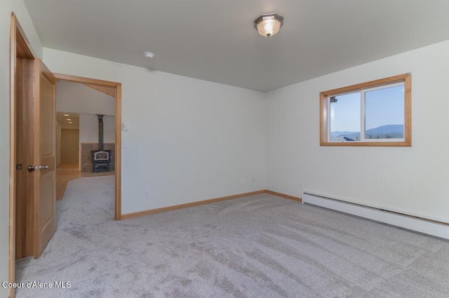156 Promise Ln, Moyie Springs, ID 83845 - empty room featuring carpet, a wood stove, and baseboard heating