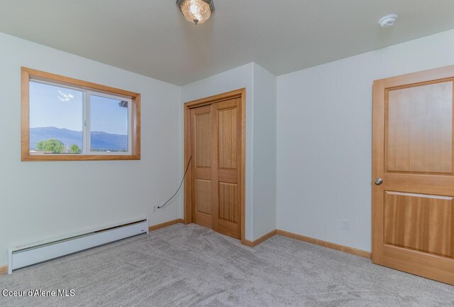 156 Promise Ln, Moyie Springs, ID 83845 - unfurnished bedroom featuring a baseboard radiator, carpet, and a closet
